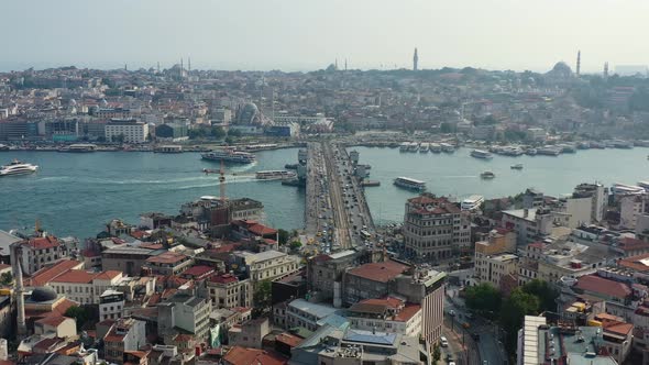 Aerial drone overlooking Karakoy in Istanbul Turkey on a sunny day as traffic crosses the Galata Bri