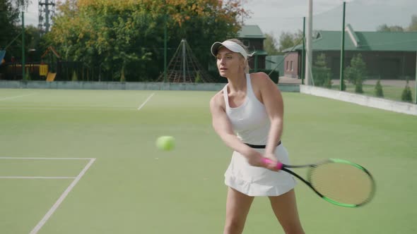Female Professional Tennis Player Hits the Ball with a Racket Practice Game on the Tennis Court Hits