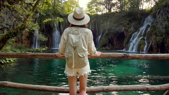 Young woman looking at waterfalls in the park in Croatia