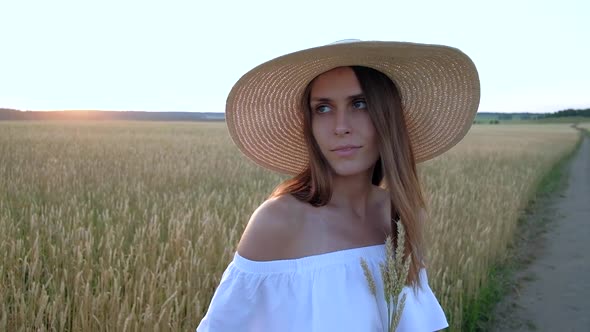 Amazing Portrait of Beautiful Woman Standing in Field of Ripe Golden Wheat