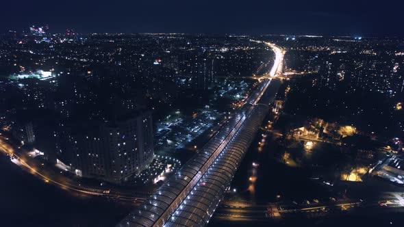 Aerial Drone Top Notch Zoom above night highway with cars, motorcycles, busesing on the viaduct, and