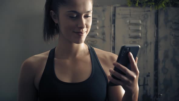 Woman Using Smart Phone with Personal Trainer Workout App at Home, Woman Preparing for Workout Using