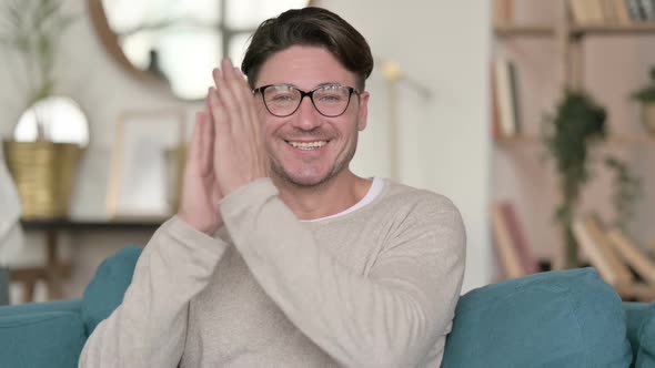 Positive Middle Aged Man Clapping at Home