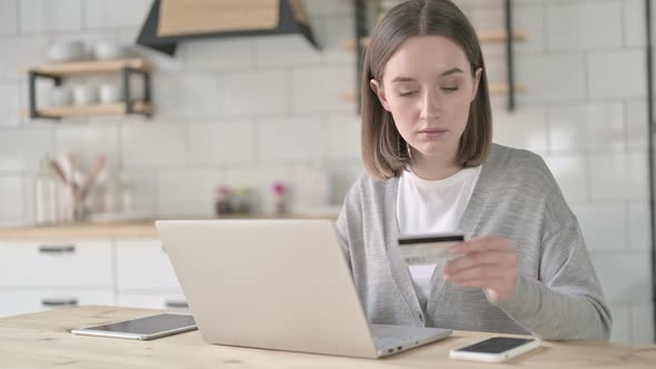 Successful Young Woman Using Credit Card on Laptop