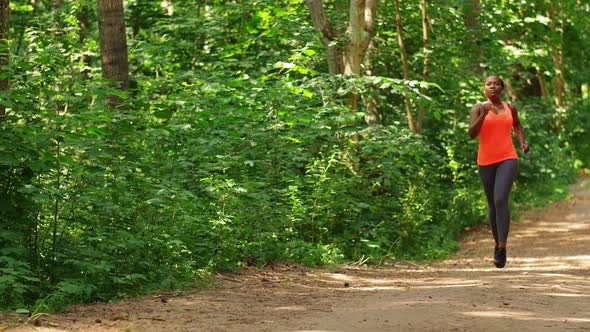 Young African American Woman Running in Forest