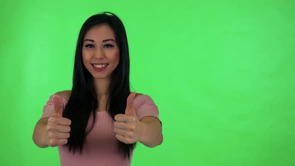 Young Attractive Asian Woman Shows Thumbs on Agreement - Green Screen Studio