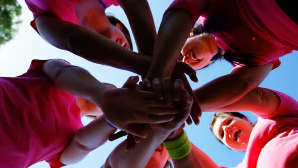 Group of women forming hand stack during obstacle course