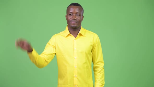 Young Happy African Businessman Waving Hand