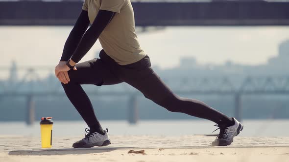 Runner Stretching And Warming-Up Before Running.Limbering-Up And Stretching Legs After Jog Running