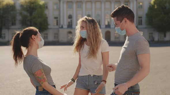 Multiracial Friends in Protective Face Mask Greet Their Elbows