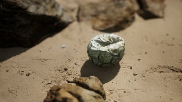Old Football Ball on the Sand Beach
