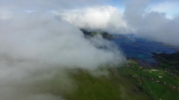 Aerial footage of clouds on green mountain top