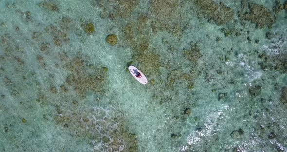 Luxury flying travel shot of a summer white paradise sand beach and aqua blue water background in co