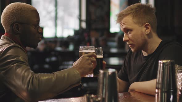 Multi-Ethnic Male Friends Drinking Beer At Bar