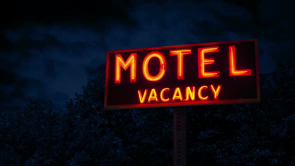Classic Motel Sign By Trees In The Evening
