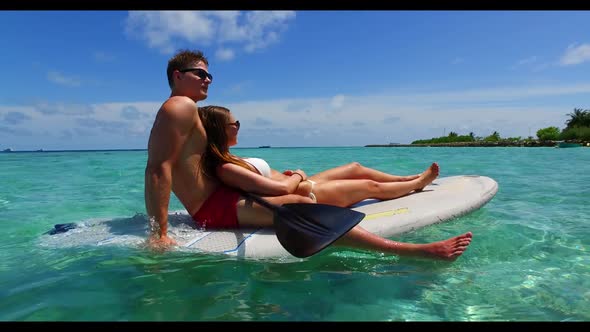 Man and woman engaged on idyllic bay beach voyage by turquoise sea and clean sandy background of the