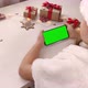 Cute girl in Santa hat holding smartphone with vertical green screen on Christmas background - VideoHive Item for Sale