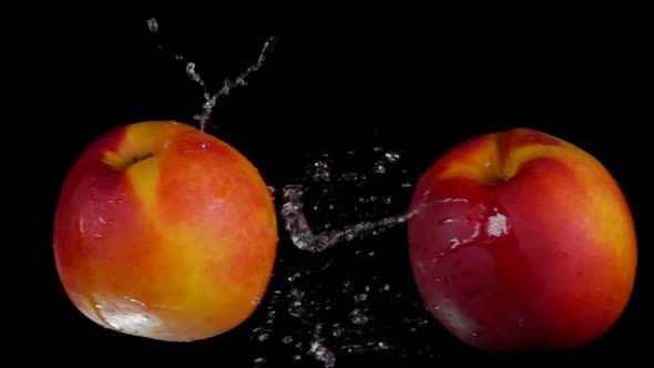 Two Sweet Peaches Collide on Black Background