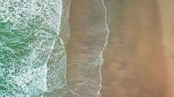 Beautiful bright waves rolling on the beach - top view