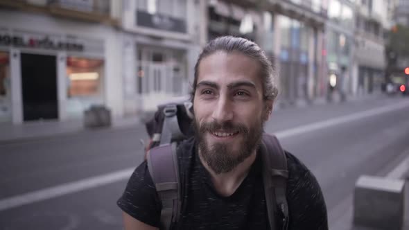 Playful Young Backpacker Winks and Makes Tongue Gestures for the Camera