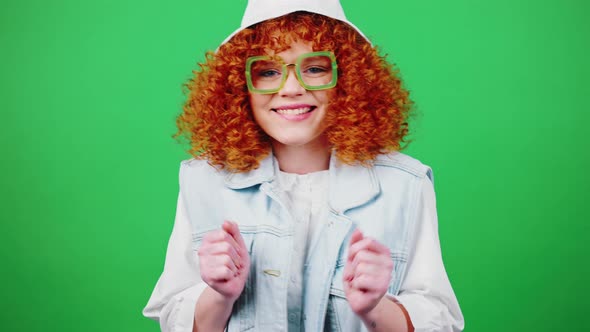 Young Playful Redhead Curly Woman in Eyeglasses and Panama Hat Dancing and Gesturing Gotcha Green