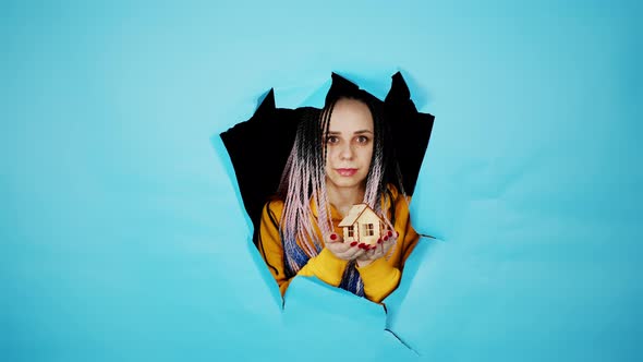 Young Woman Holding Small Wooden House