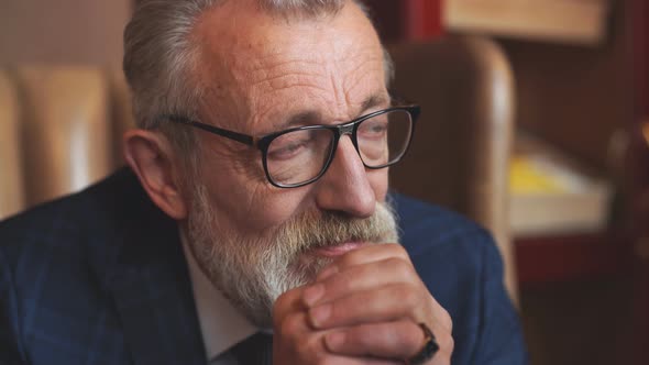 Portrait of Serious Pensive Old Male In Formal Blue Suit