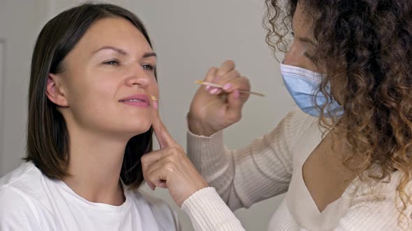 Professional Cosmetologist Performs Wax Epilation on the Patient's Upper Lip