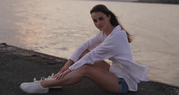 Young Cute Woman Relaxing Sitting on the Pier