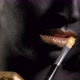 Closeup of a Woman with Black and Gold Paint and a Paintbrush Posing in Studio - VideoHive Item for Sale