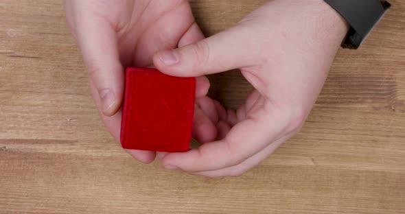 Man Hand Opening a Small Red Box with Engagement Diamond Ring