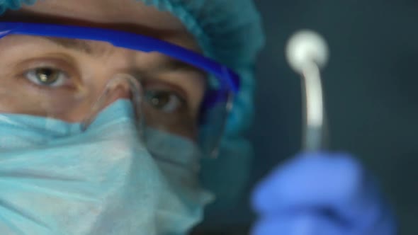 Medical Worker Examining White Tablet in Forceps, Antibiotic and Antiviral Drug