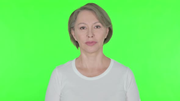 Serious Old Woman on Green Background