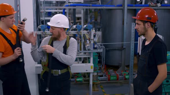 A Master Instructor Conducts Safety Training for a Team of Hard Hat Workers at an Oil Refinery