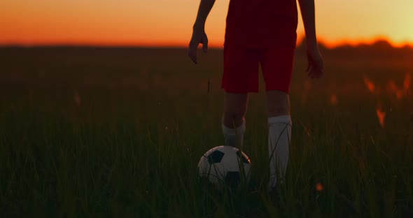 Tracking a Boy Football Player Running with a Ball on Camera at Sunset