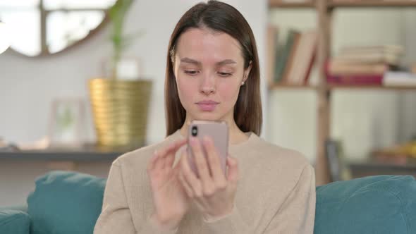 Young Woman Using Smartphone at Home 