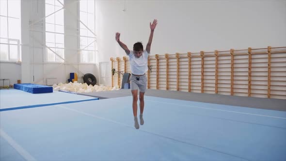 A Teenager Boy Is Doing a Cartwheel and a Triple Back Flip in Gym, Steadicam.