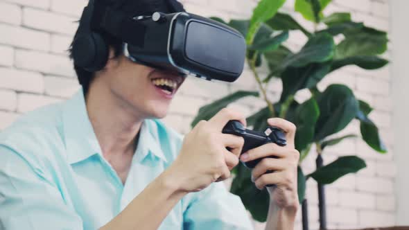A handsome man playing the game using VR glasses on a sunny day.