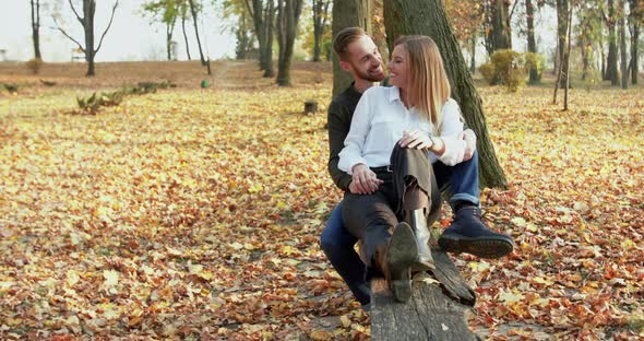 Happy, Lovely Couple Having Relax in Embraces and Kisses on Park Bench