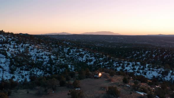 Aerial orbits SUV parked on scenic overlook in desert national forest, 4K