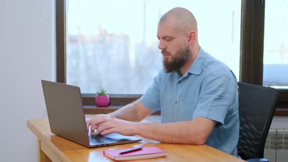 Senior Man Employee Works at Home Office at the Computer