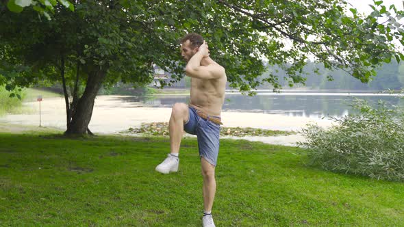 The man is exercising in the park. Fitness man doing fitness exercises outdoors.