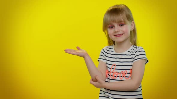 Little Kid Child Girl Showing Thumbs Up and Pointing at Left on Blank Space on Yellow Background