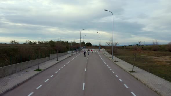 Young women gathering on empty road to practice skateboarding