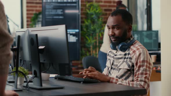 Relaxed Software Developer Wearing Wireless Headphones Smiling Working Looking at Computer Screen