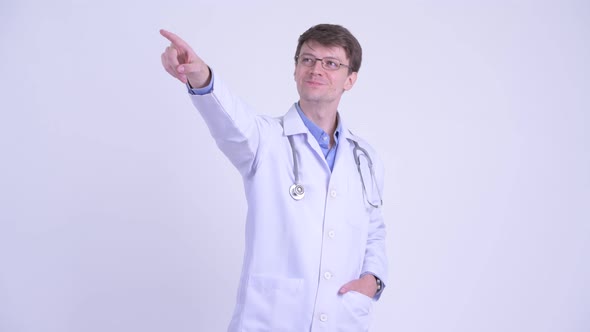 Happy Young Handsome Man Doctor Pointing Finger