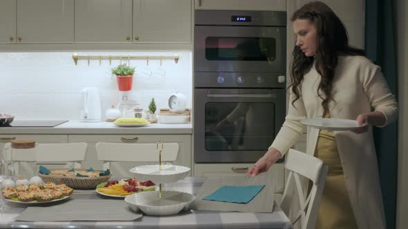 Woman Setting the Table for Family Celebration Dinner in the Kitchen