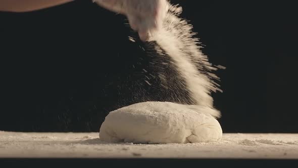 Male Hands Sprinkle a Piece of Baking Dough with Flour