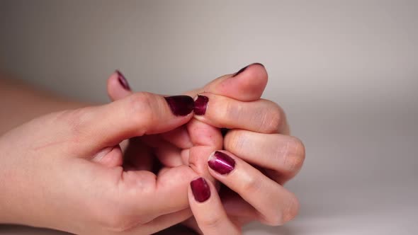 Nervous Woman Picks at Her Red Nails