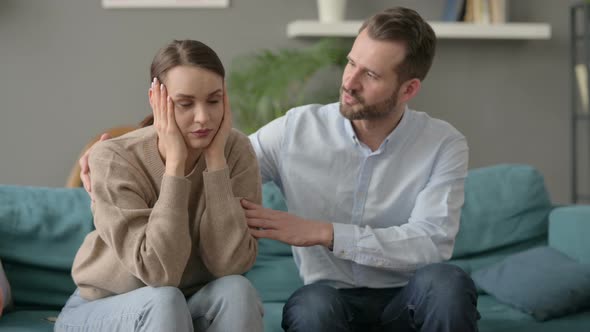 Man Trying to Comfort Upset Female Partner on Sofa